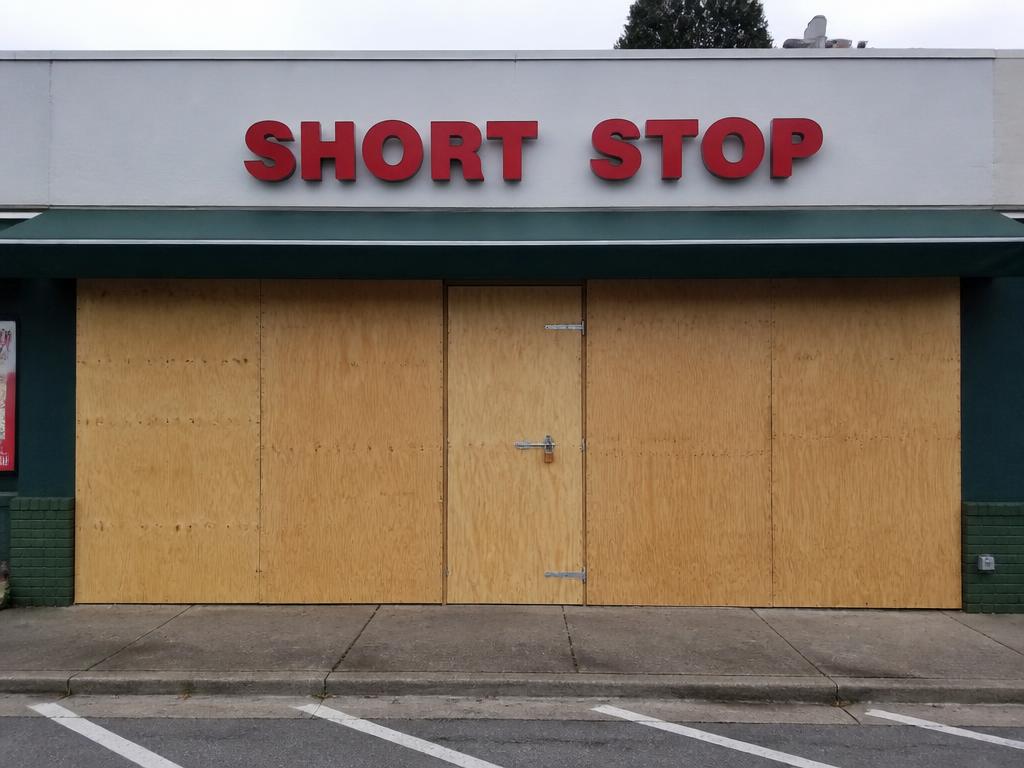 Storefront fully boarded and secured with clean plywood panels