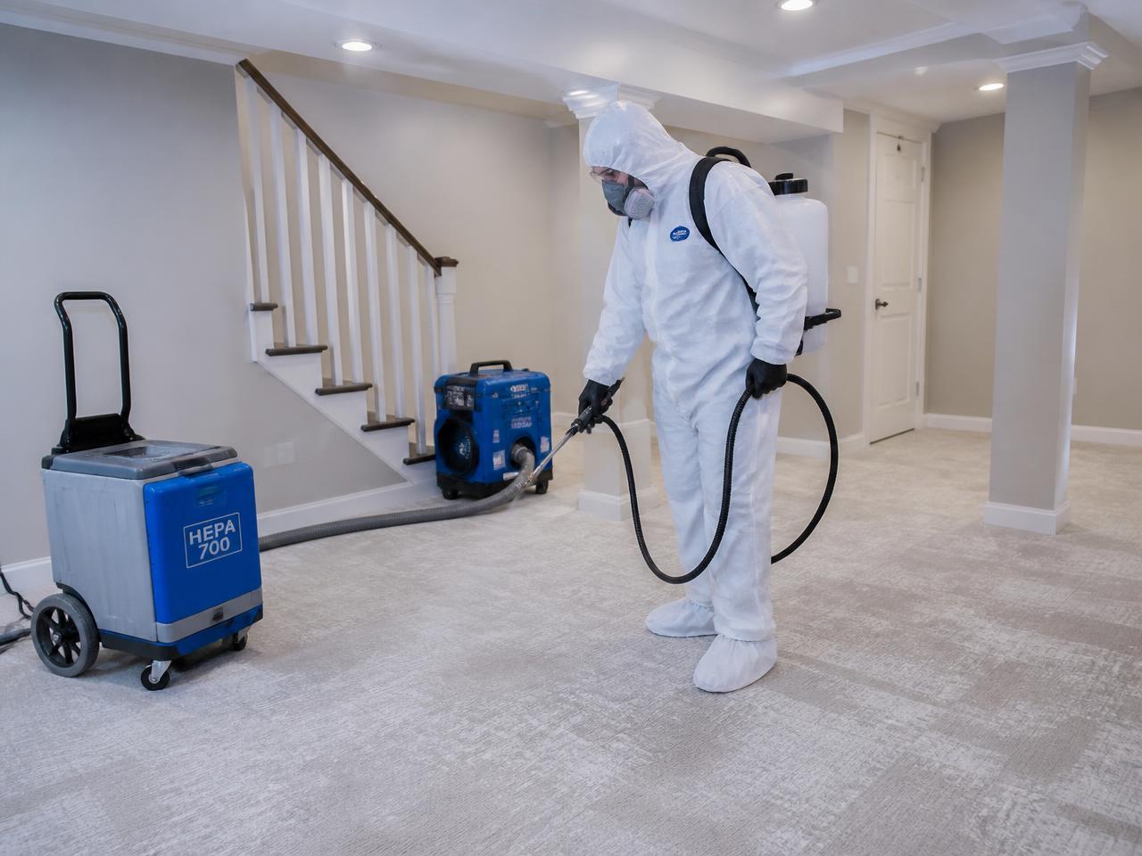 Technician in full protective equipment performing sewage cleanup in a Greenwood Indiana home