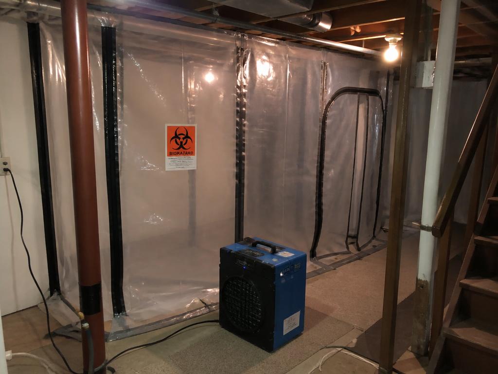 Containment barrier and air scrubber isolating a contaminated basement area