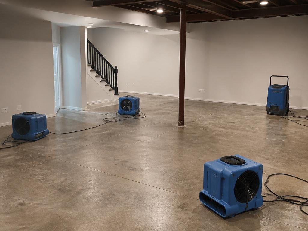 Air movers and dehumidifier drying a cleaned basement